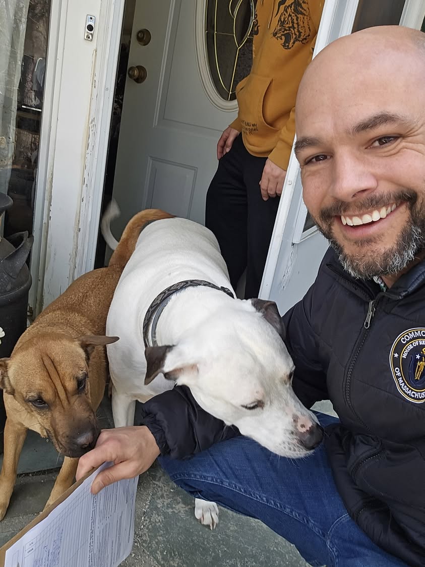 Joe McKenna with two friendly dogs at a doorstep